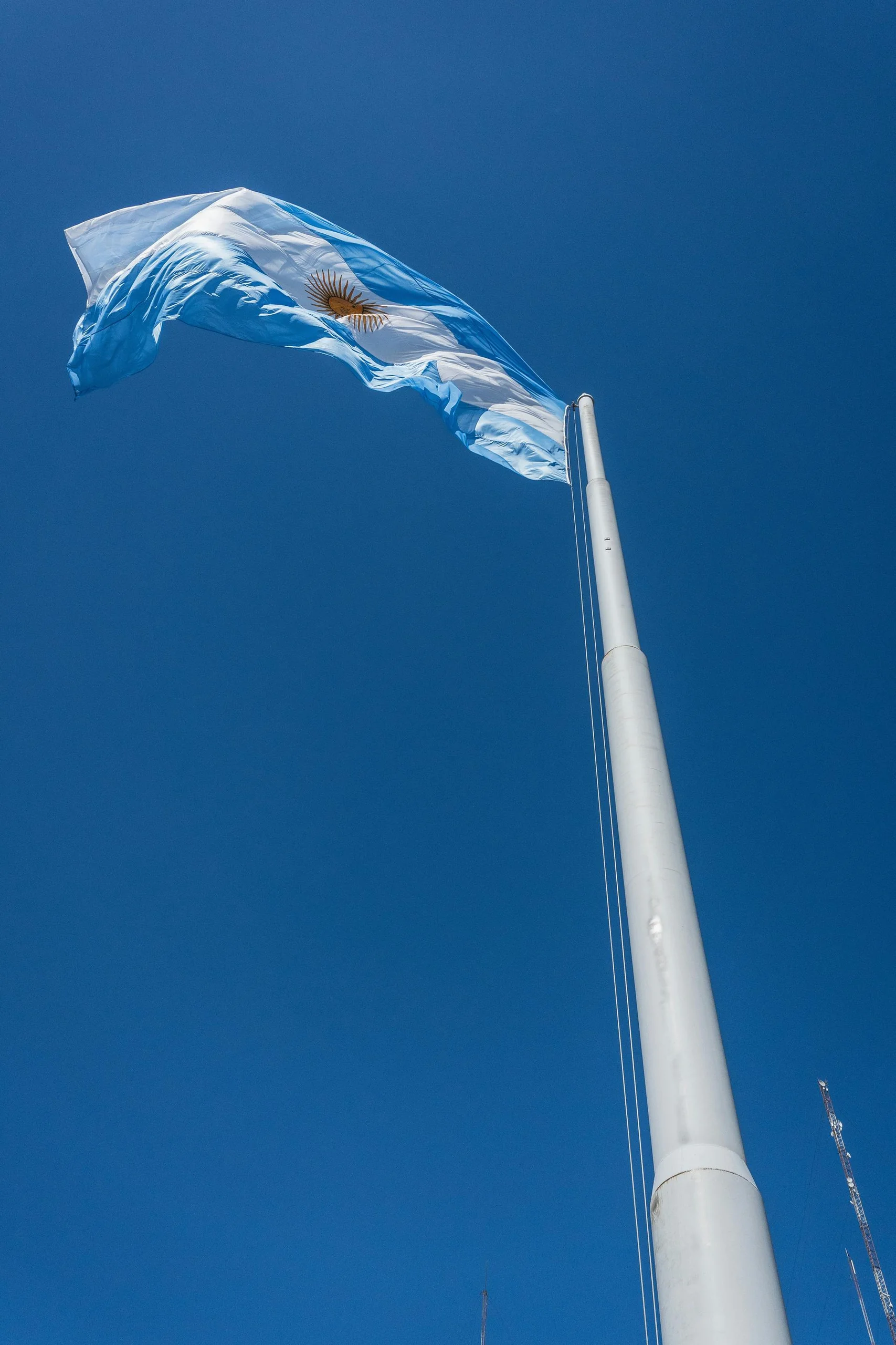 Argentine flag against a deep blue sky