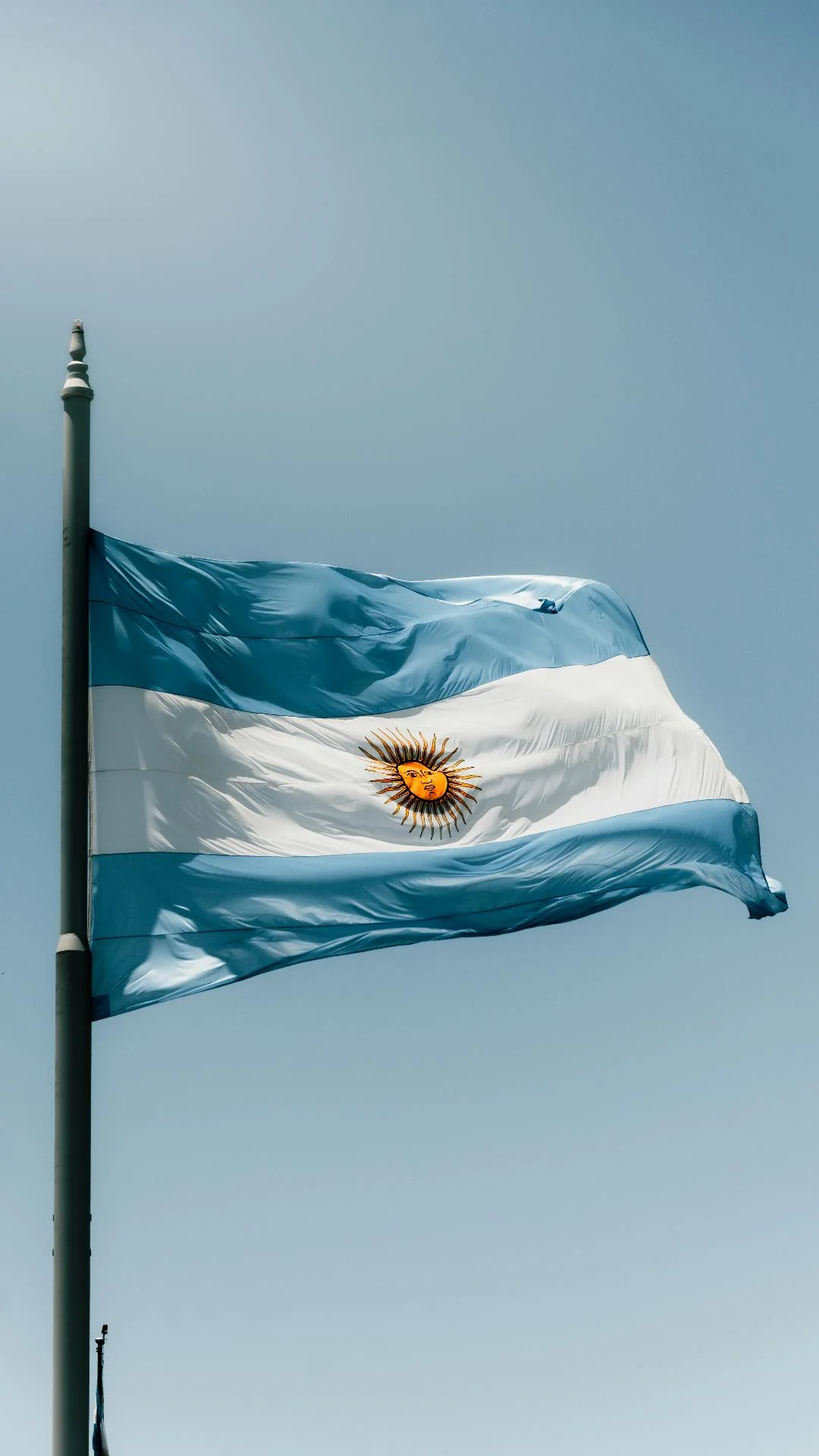Argentine flag with the Sun of May against a clear sky