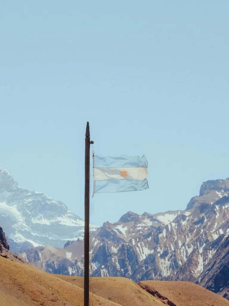 Argentine flag against the Andes mountain landscape